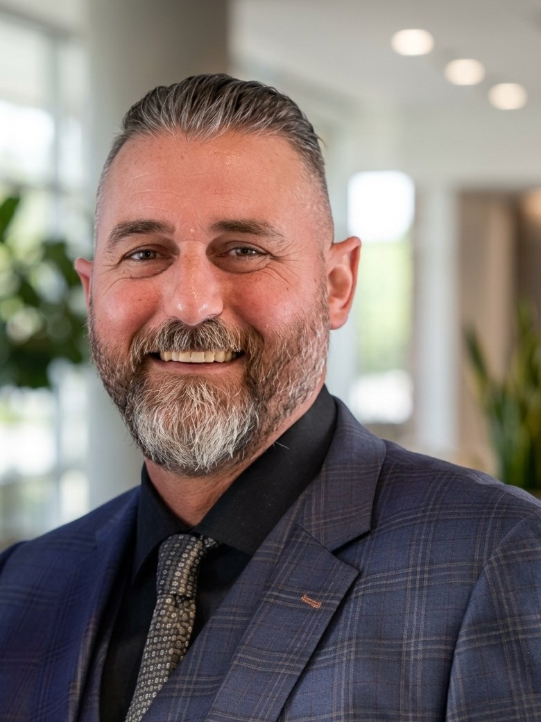 Jeremy T. Haas in a dark plaid suit, photographed indoors